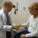 Dr. Truslow performs a routine examination of the hand of a patient with rheumatoid arthritis.