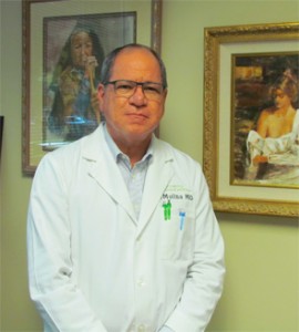 Dr. Molina in his office, surrounded by his paintings.