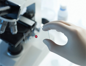 A scientist places a blood sample under a microscope in the laboratory.