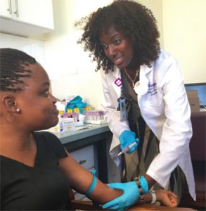 Ashira Blazer, MD, with a patient  at a clinic in Ghana, where she  researches SLE.
