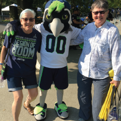 Rosemary Brechtelsbauer (left) and her wife, Cheryl (right) enjoying life at a Seattle Seahawks football game with the mascot. 