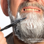 Hair dye being applied to a man’s beard.