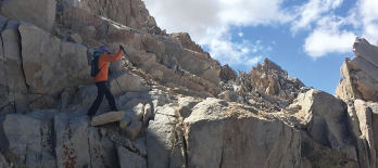 Dr. Criswell hikes a narrow rocky ledge close to the top of Mt. Whitney.