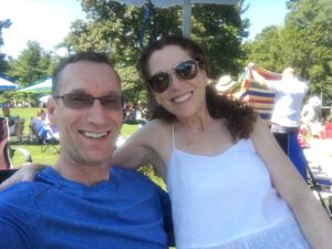 Two people sitting on a grassy hill.