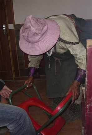 A Tibetan woman learning to use a portable toilet.