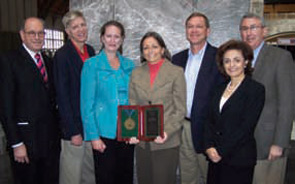 REF Past-President, Leslie J. Crofford, MD, (blue jacket) presents a plaque to the Arthritis Foundation, Inc. for its recent commitment of $1 million to the Within Our Reach campaign. 