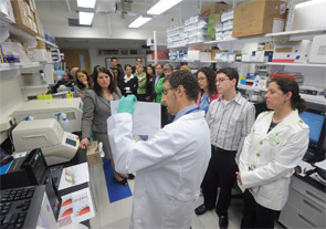 Congressional staffers gather around scientist Dr. Massimo Gadina, from the NIAMS Translational Immunology Section, to hear how the discoveries in his lab further enhance patient diagnoses and outcomes.