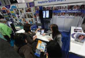 Annual meeting attendees at the Exhibit Hall (top), main staircase, (middle), Poster Hall (bottom), and hospital booths (bottom inset).